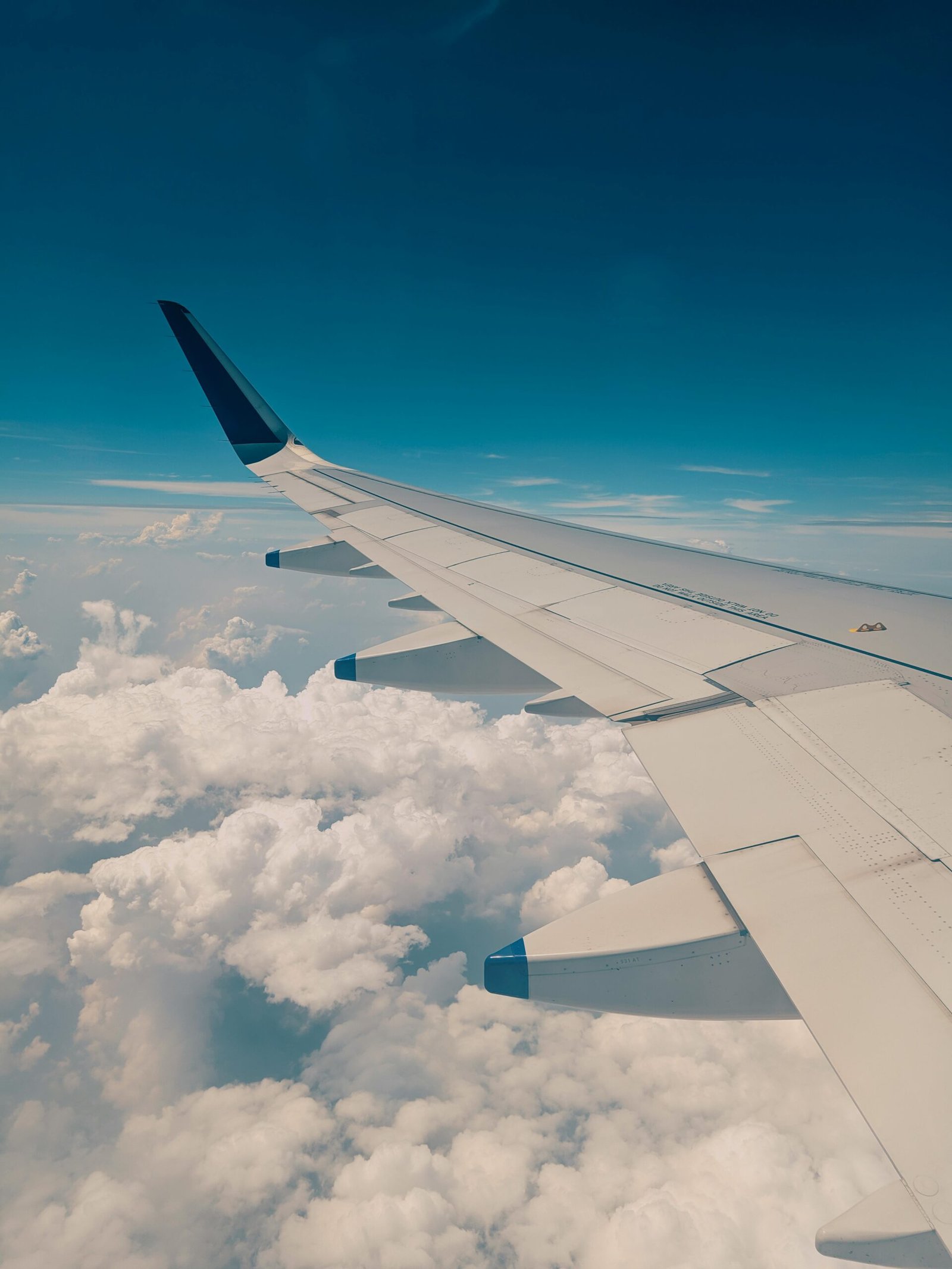 View from airplane window showing wing above clouds representing Ghana's aviation sustainability goals