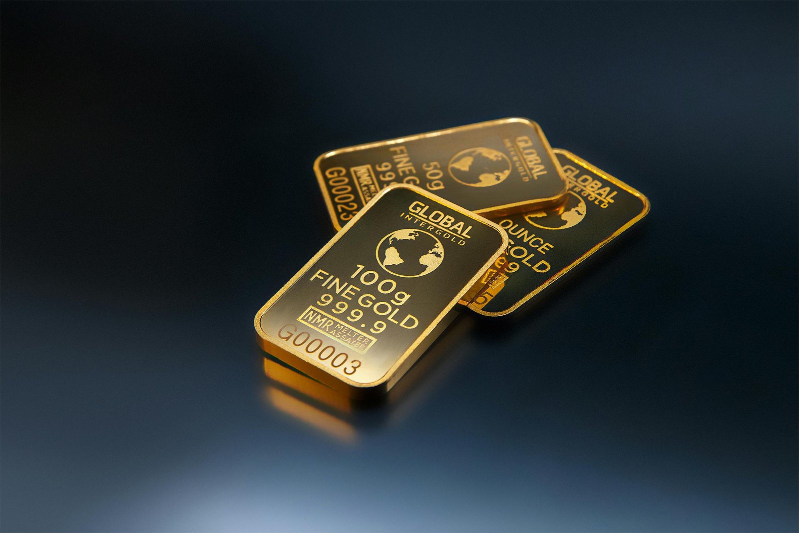 Three gold bars on dark background representing Burkina Faso's record gold production and IMF funding