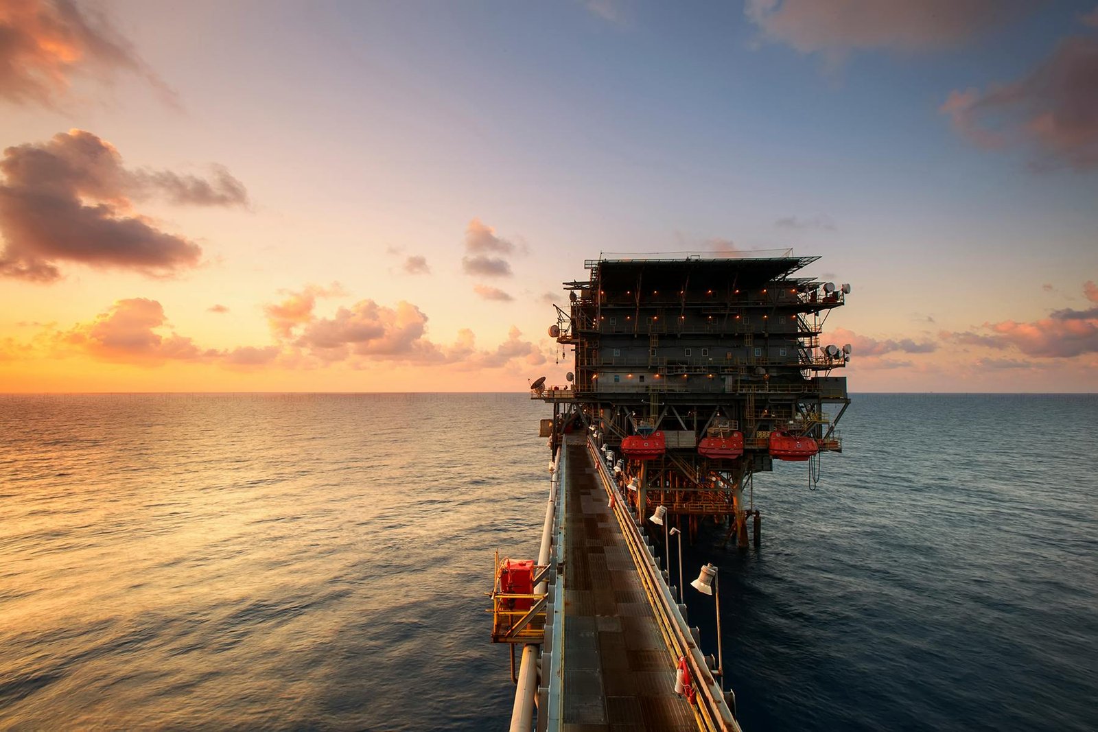 Offshore oil drilling rig on the ocean at sunset, representing Ghana's TEN fields oil operations