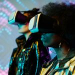 Two women wearing VR headsets immersed in a vivid digital world. Explore technology.