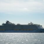 A large cruise ship sailing across the open sea under a clear sky, highlighting maritime travel.