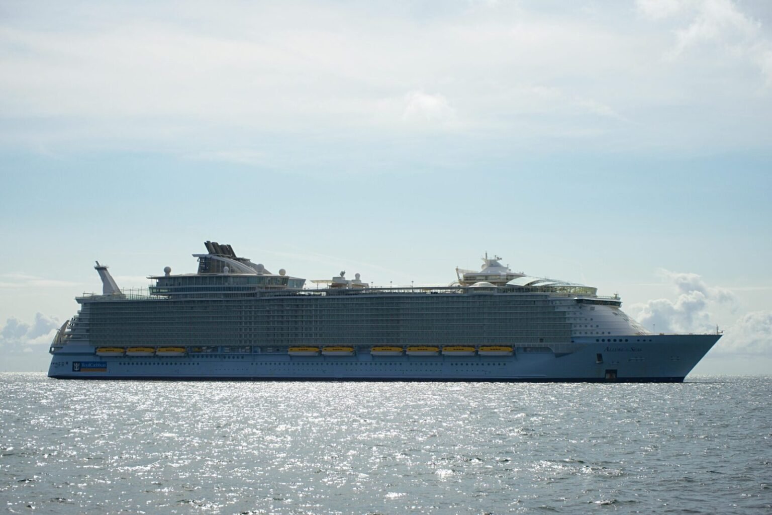 A large cruise ship sailing across the open sea under a clear sky, highlighting maritime travel.
