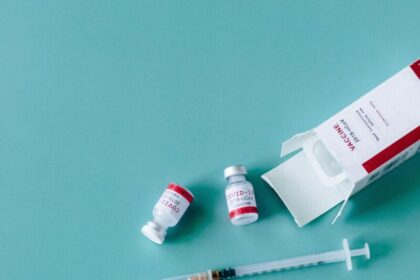 Syringes, vaccine vials, and face mask ready for COVID-19 vaccination.