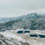 Aerial view of a snow-covered mountain landscape with solar panels.