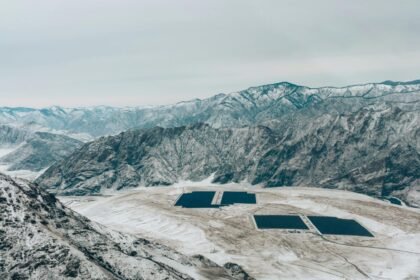 Aerial view of a snow-covered mountain landscape with solar panels.