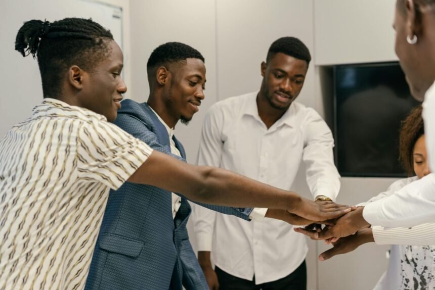 A diverse group of professionals engaging in a team-building exercise in an office environment.