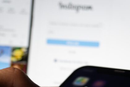 A person holding a smart phone with social media on the screen