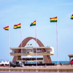 Ghana's independence square with flags and a clear sky.