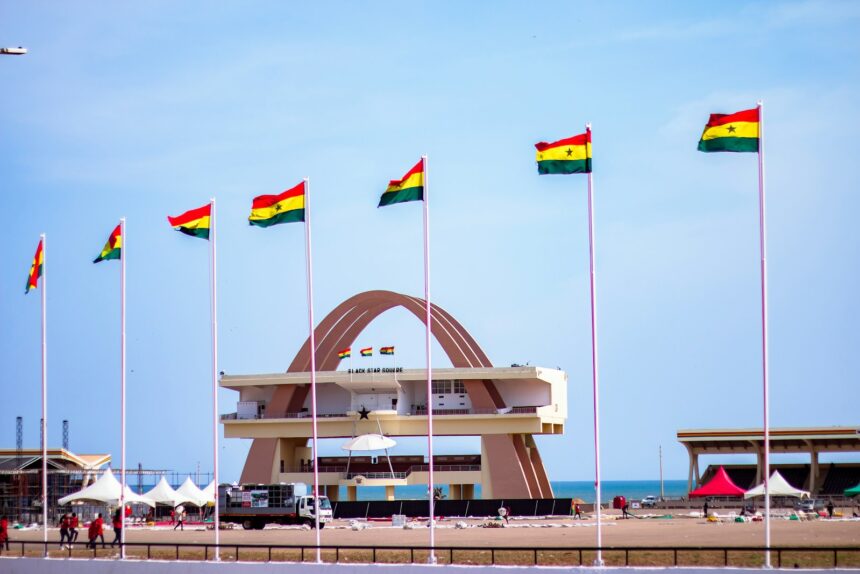Ghana's independence square with flags and a clear sky.