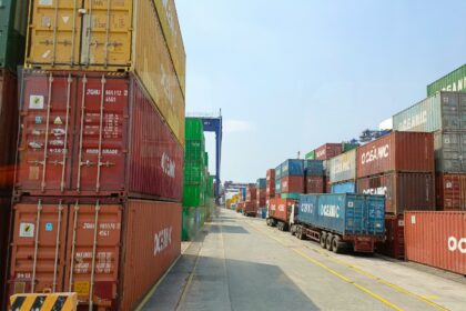 a long line of shipping containers on the side of a road