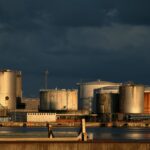 a large industrial area with a body of water in front of it