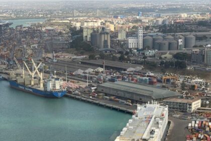 Aerial view of a bustling sea port with cargo ships and containers, highlighting global trade logistics.