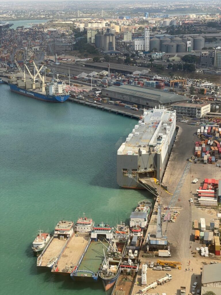 Aerial view of a bustling sea port with cargo ships and containers, highlighting global trade logistics.