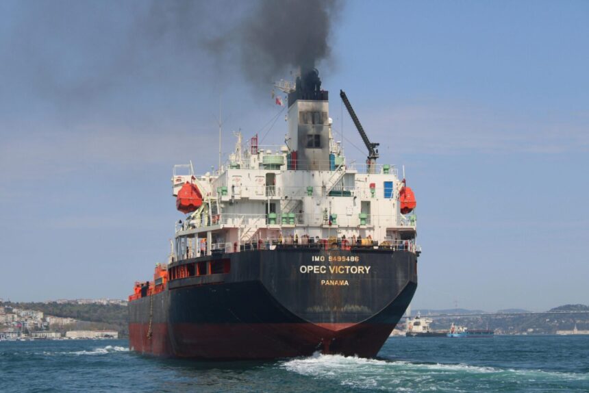 Oil tanker OPEC Victory sailing on the Bosporus under clear skies, emitting smoke.
