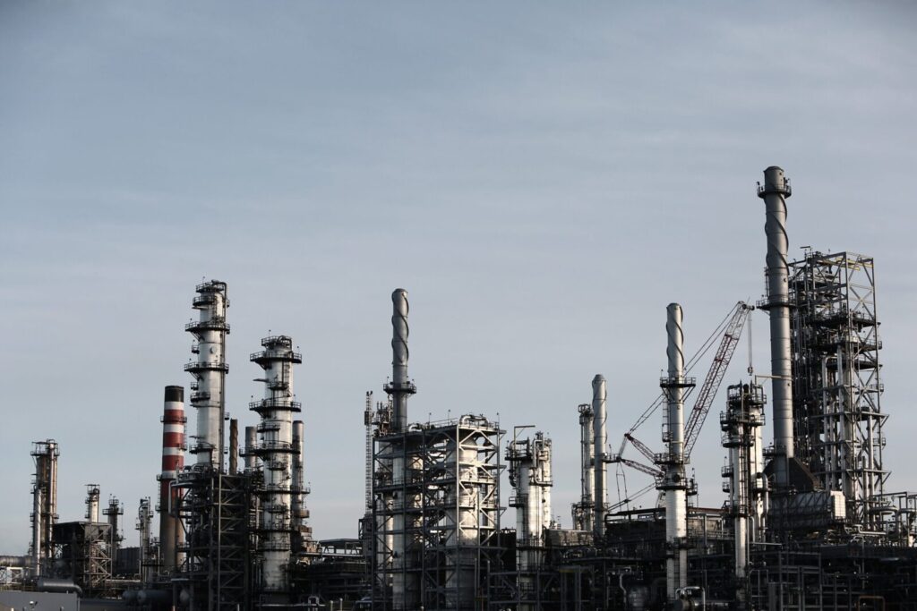 Skyline view of an industrial factory with tall chimneys against a clear sky.