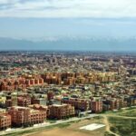 Stunning aerial view of Marrakech cityscape with Atlas Mountains in the background.
