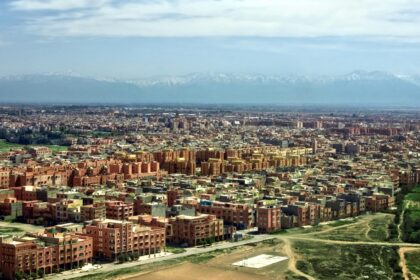 Stunning aerial view of Marrakech cityscape with Atlas Mountains in the background.