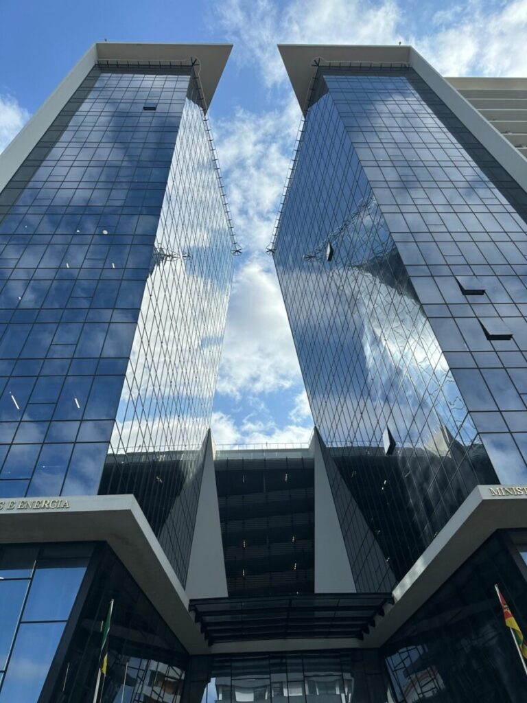 A vibrant view of contemporary skyscrapers with glass facades under a bright sky in Maputo, Mozambique.