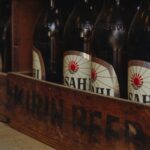 Close-up of vintage beer bottles in a rustic wooden crate from a traditional brewery in Tokyo, Japan.