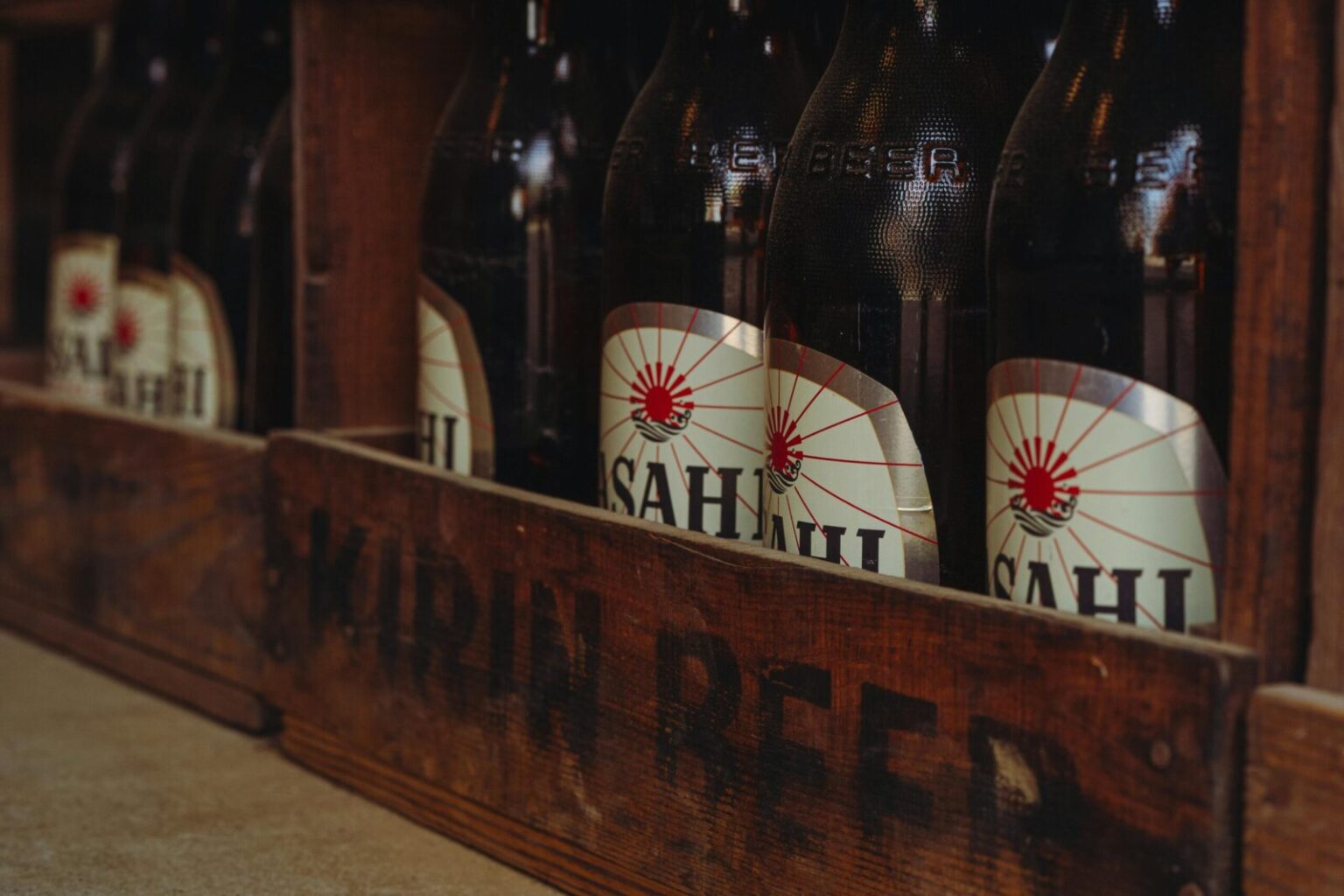 Close-up of vintage beer bottles in a rustic wooden crate from a traditional brewery in Tokyo, Japan.
