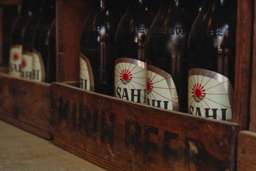 Close-up of vintage beer bottles in a rustic wooden crate from a traditional brewery in Tokyo, Japan.