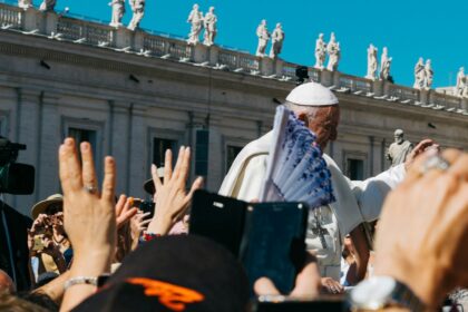 Pope surrounded with people during daytime