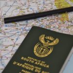A South African passport rests on a detailed map, symbolizing travel and exploration.