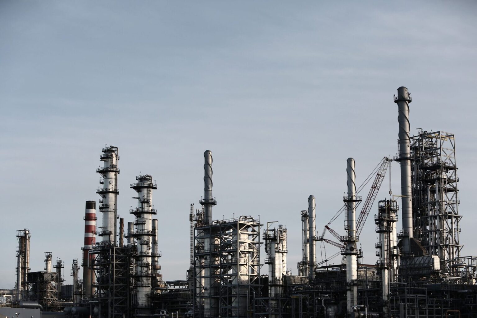 Skyline view of an industrial factory with tall chimneys against a clear sky.