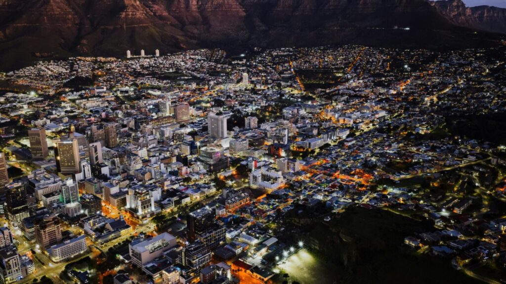 A stunning aerial view of Cape Town city lights at night against Table Mountain.