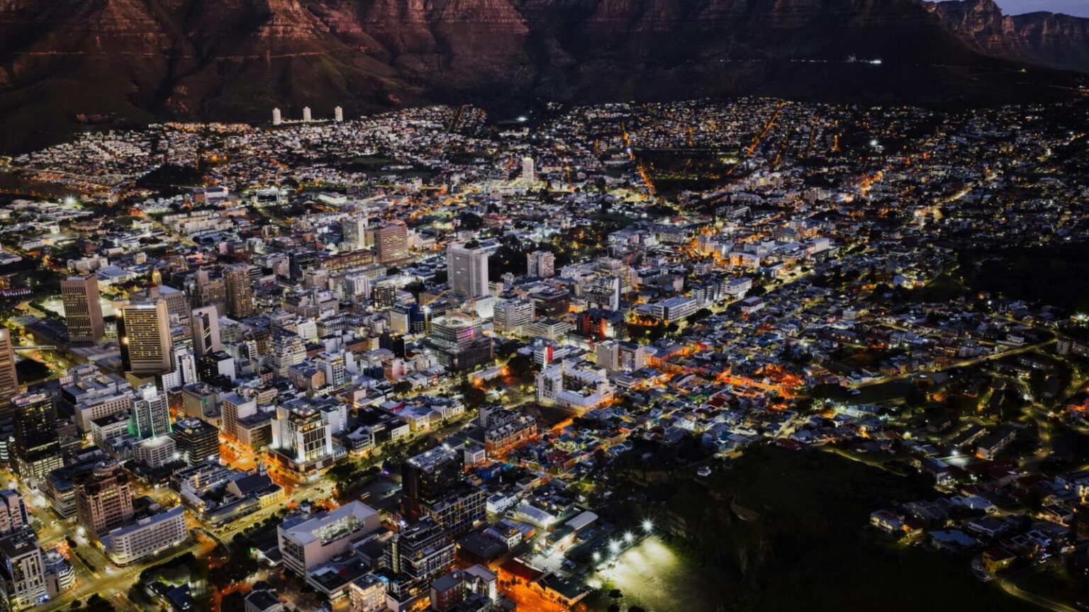 A stunning aerial view of Cape Town city lights at night against Table Mountain.