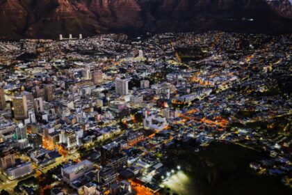 A stunning aerial view of Cape Town city lights at night against Table Mountain.