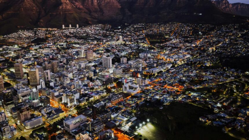 A stunning aerial view of Cape Town city lights at night against Table Mountain.