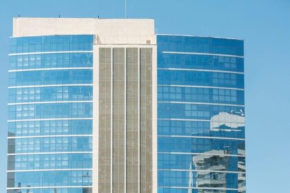 A modern glass skyscraper reflecting the cityscape in Porto Alegre, Brazil.