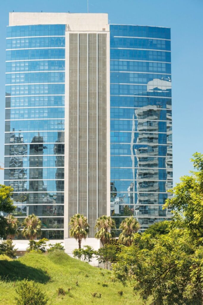 A modern glass skyscraper reflecting the cityscape in Porto Alegre, Brazil.