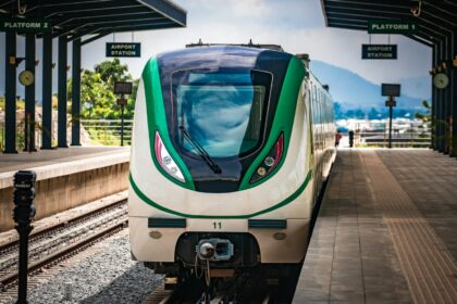 A green and white train pulling into a train station