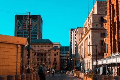 A vibrant city street scene with people walking among urban architecture and buildings.